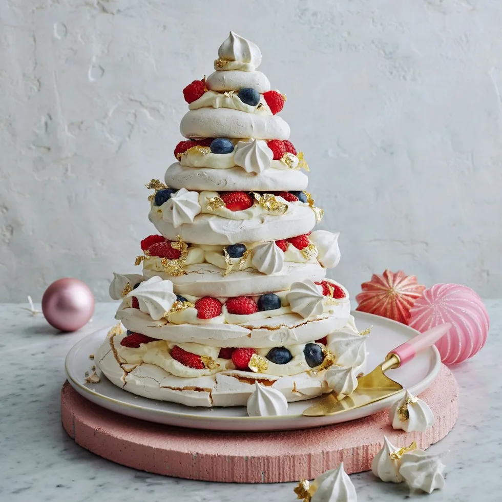 seven-layered pavlova Christmas tree on pink board with white background