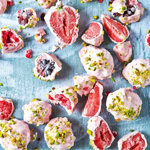 Berries coated in frozen yoghurt and sprinkled with nuts