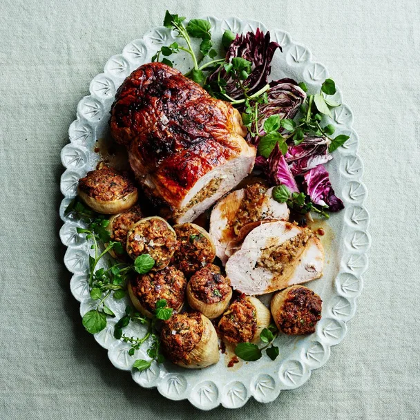 Roast turkey breast fillet with stuffing on a white oval serving dish.