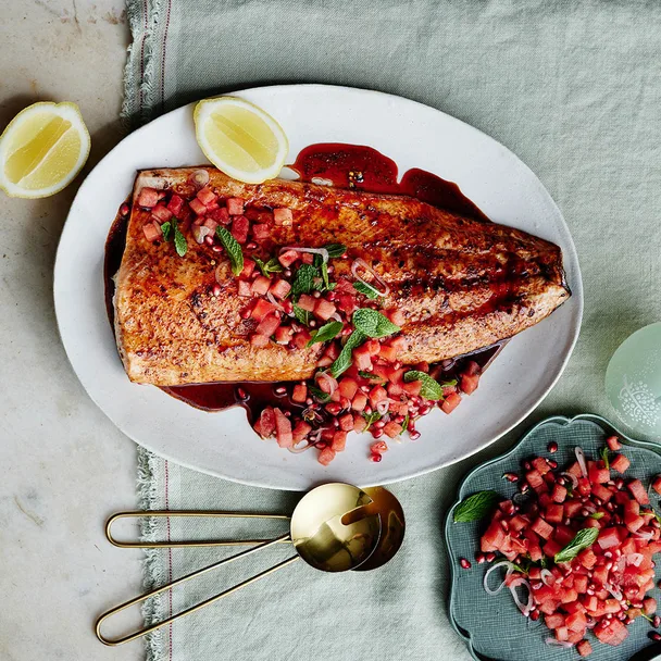 roast salmon on a platter with a salsa in a bowl