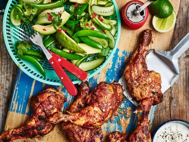 chicken marylands on a board with a bowl of salad