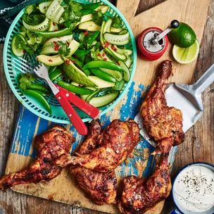 chicken marylands on a board with a bowl of salad