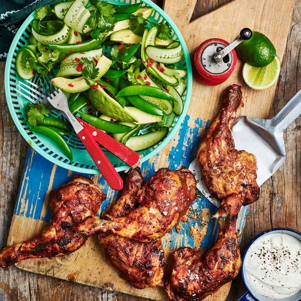 chicken marylands on a board with a bowl of salad