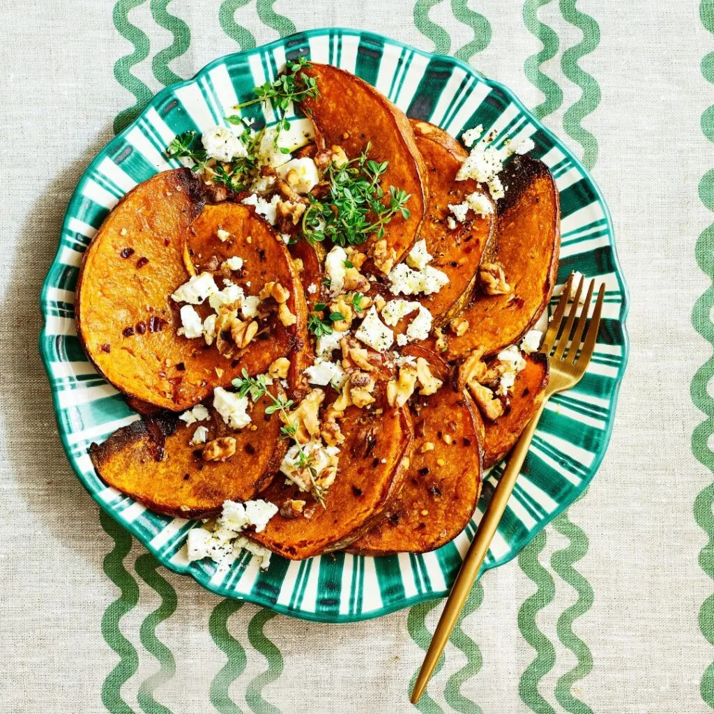 pumpkin wedges on a green striped plate with a fork