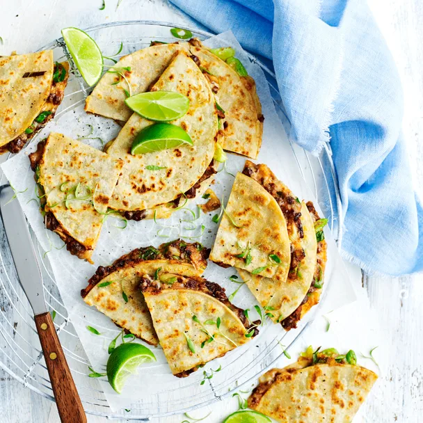 Quesadilla with black bean and corn with lime wedges