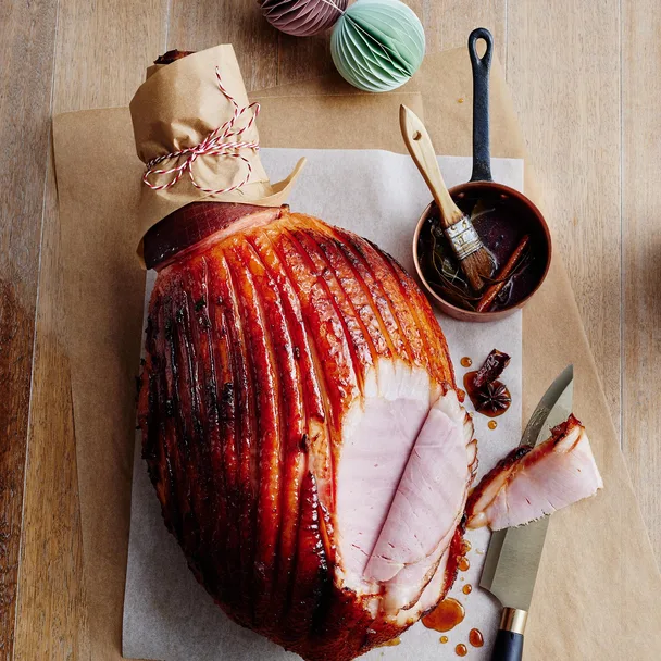Glazed ham on a board with slices missing
