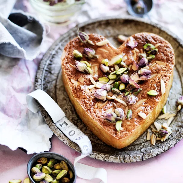 Heart-shaped syrup cake on pink background