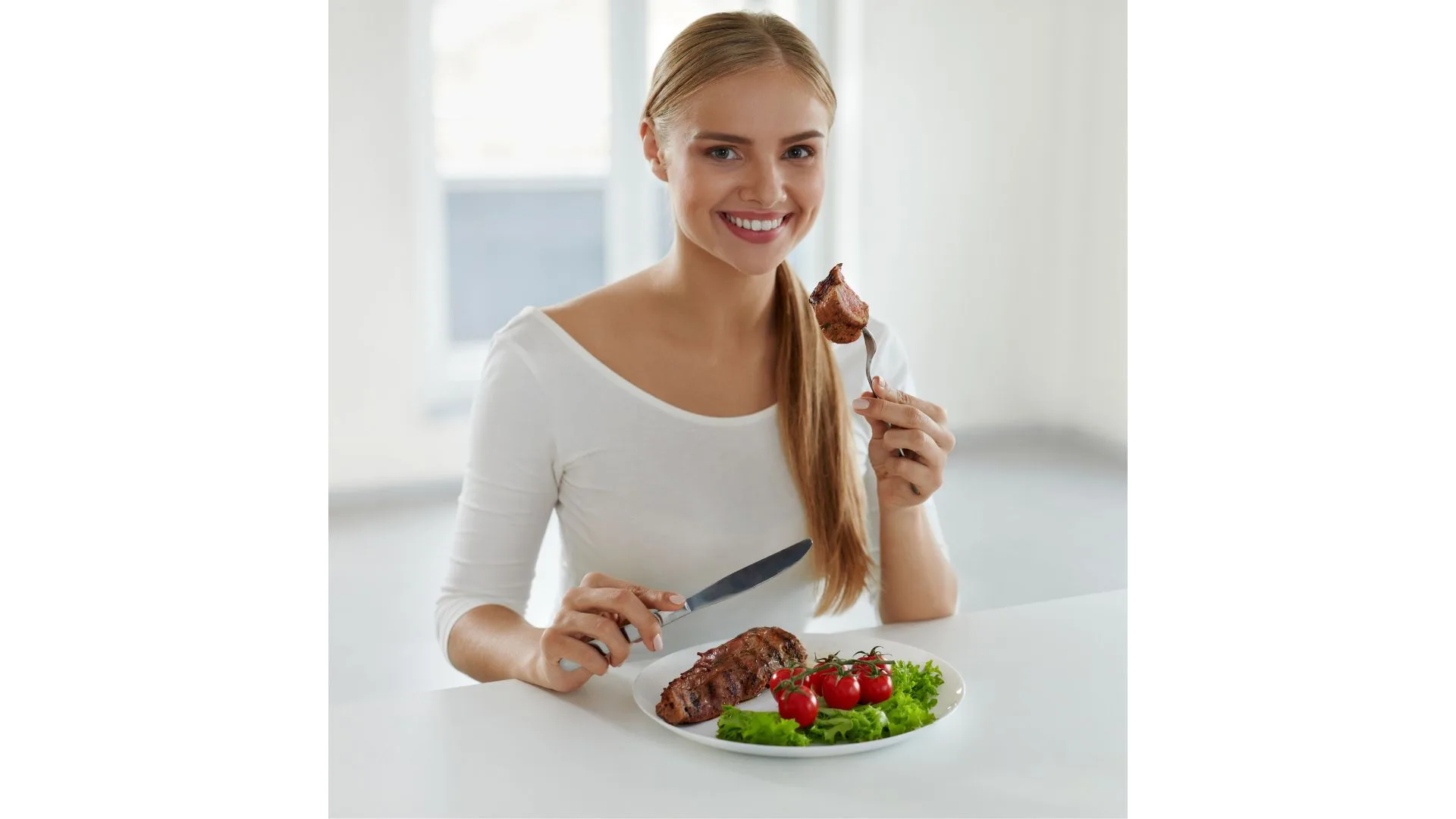 Young woman eating steak and salad at a bench