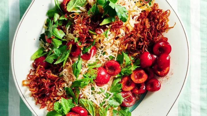 Cherry & herb jewelled rice salad on a white serving platter