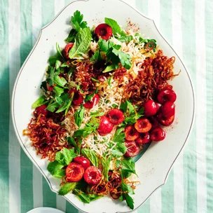 Cherry & herb jewelled rice salad on a white serving platter