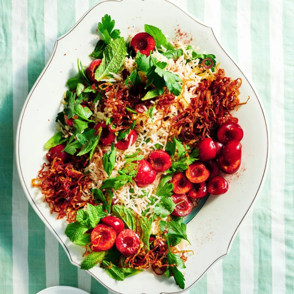 Cherry & herb jewelled rice salad on a white serving platter