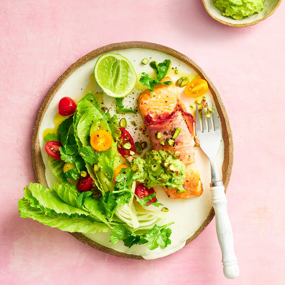 Prosciutto-wrapped ocean trout on a dinner plate