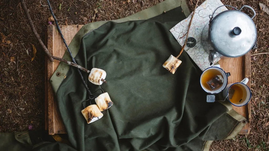 Marshmallows on sticks and a pot of tea and cups