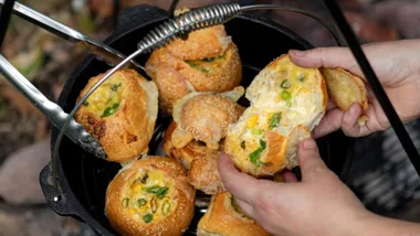 Cheesy cob loaf baked rolls in a camp oven, one of our favourite camping meals