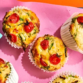 An aerial view of the top of tomato and cheese savoury muffins with spinach.