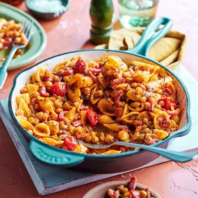 A blue pan full of red smoky capsicum pasta.
