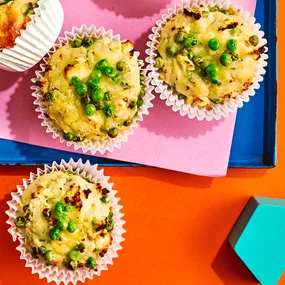 An aerial view of zucchini muffins with feta and peas.