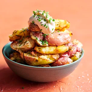 Crisp crushed herby roast potatoes in a bowl