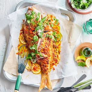 Whole baked fish with tahini, pickled shallot and fresh herbs
