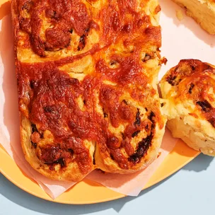 A group of cheese and vegemite scrolls with one broken off and ready to eat.