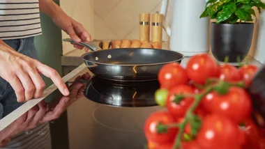 Person preparing to cook with induction cookware on an induction cooktop