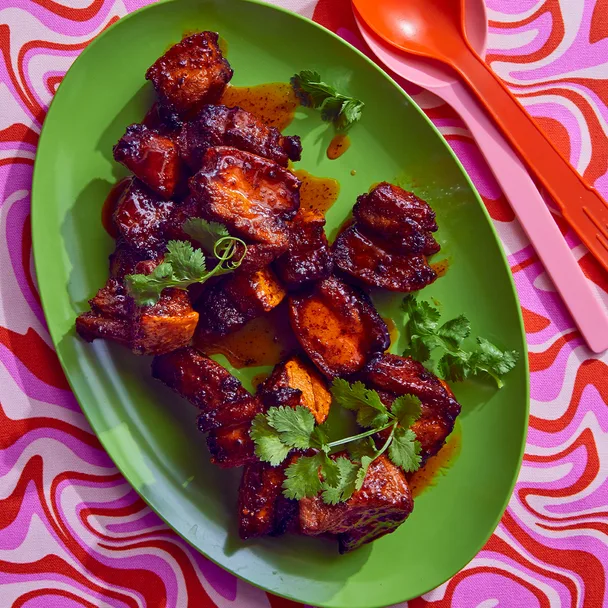 Sticky pork belly bites on a green platter