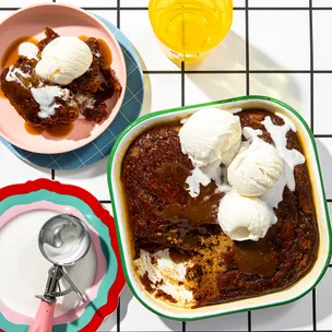 Vegan sticky date pudding in a baking dish, topped with ice-cream