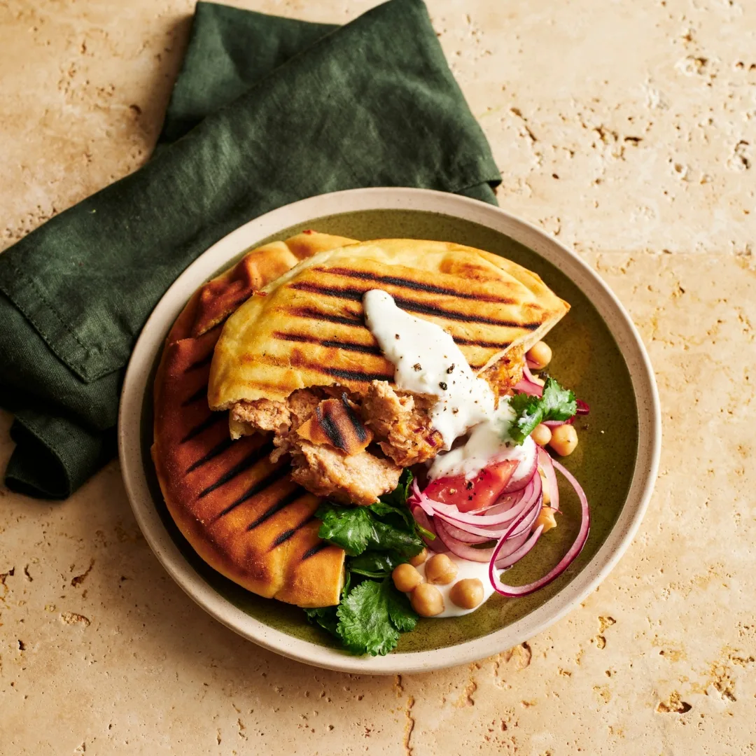 Chicken shawarma pita cut in half with salad and yoghurt