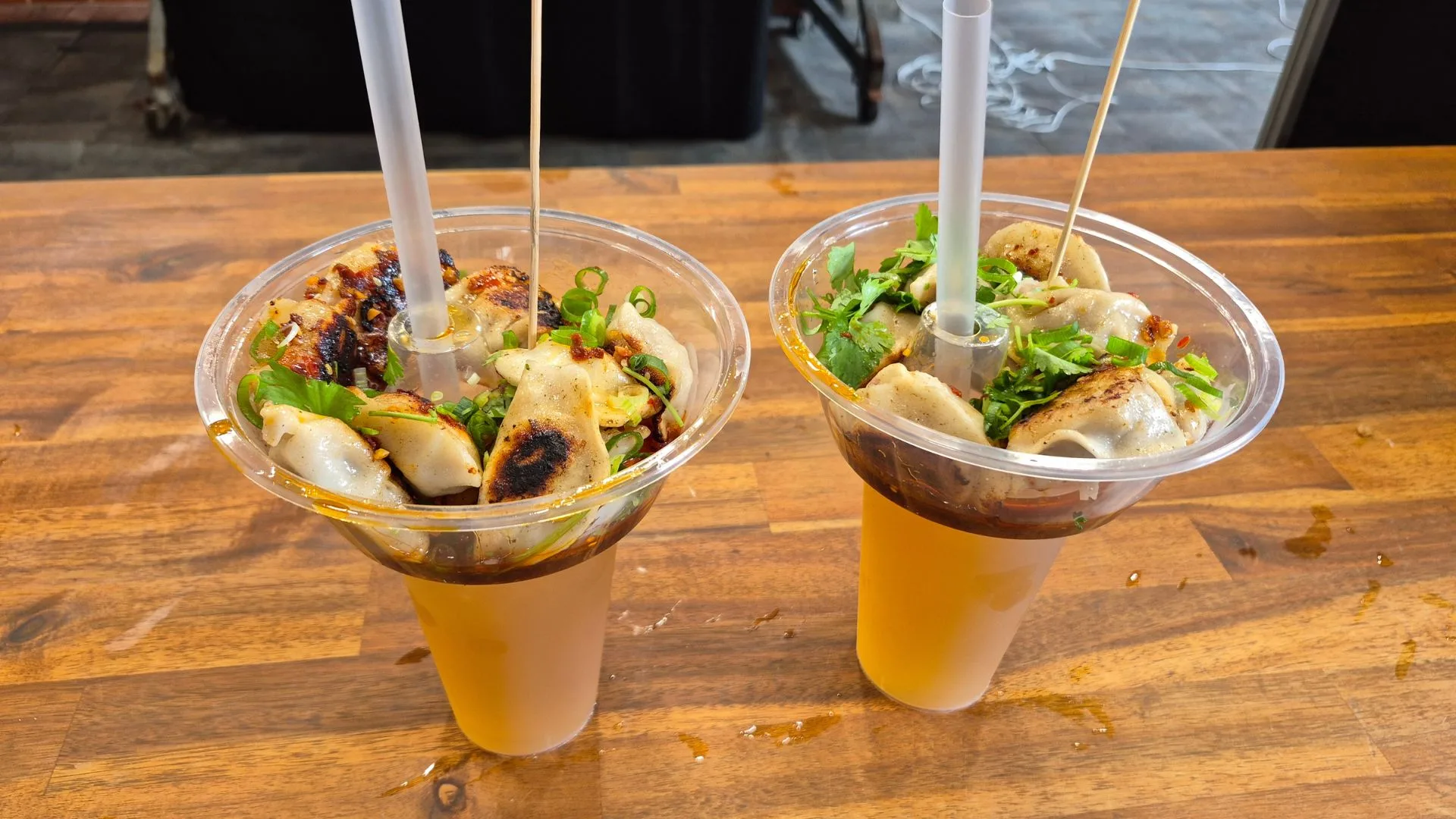 Plastic drink container with a second container on top containing dumplings