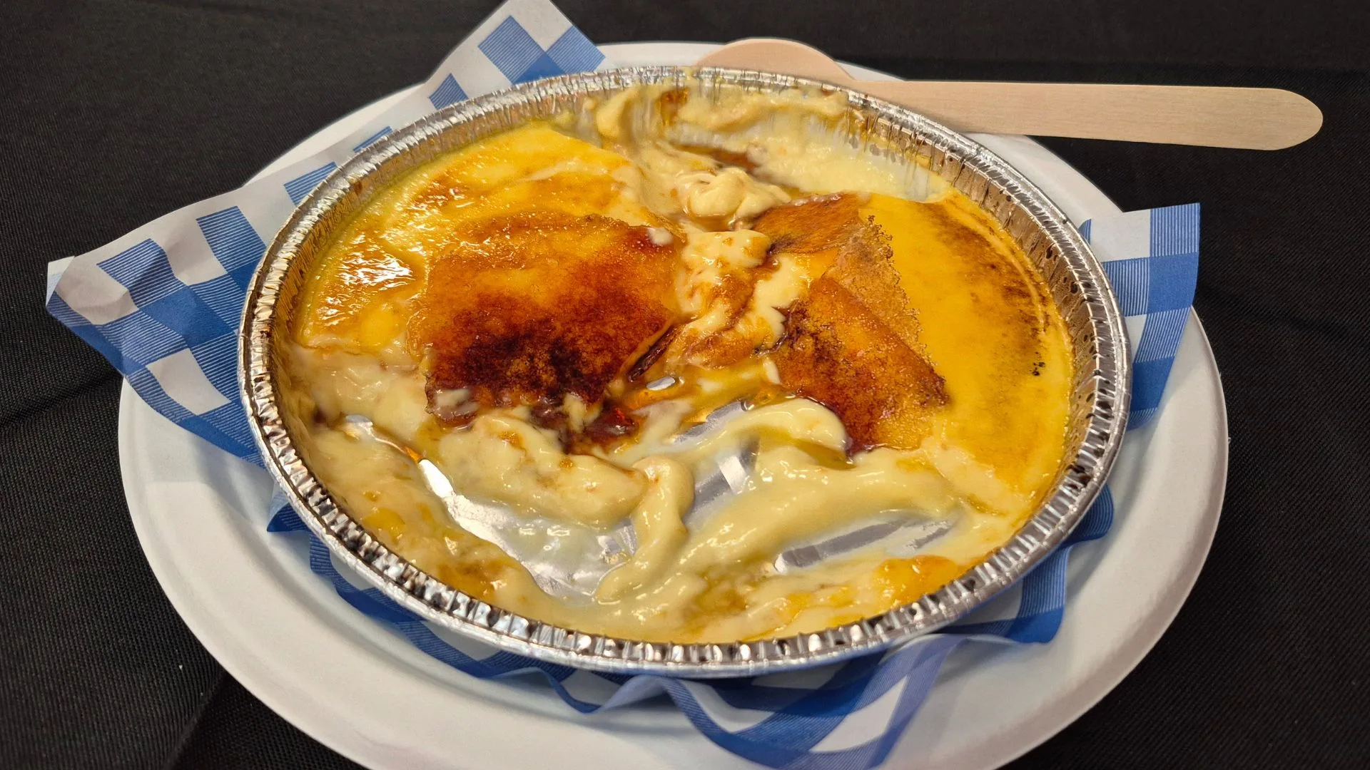 Giant cr&egrave;me br&ucirc;l&eacute;e in a foil dish on a plate