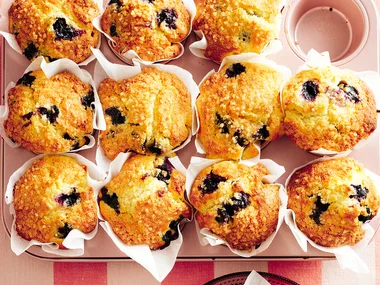 Blueberry muffins straight from the oven in muffin tins