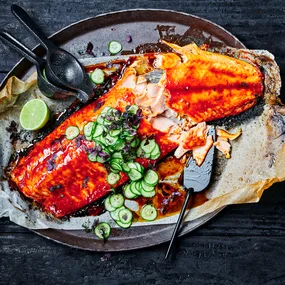 Barbecued side of salmon with a quick pickled cucumber on a platter