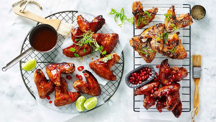 four types of chicken wings on metal racks
