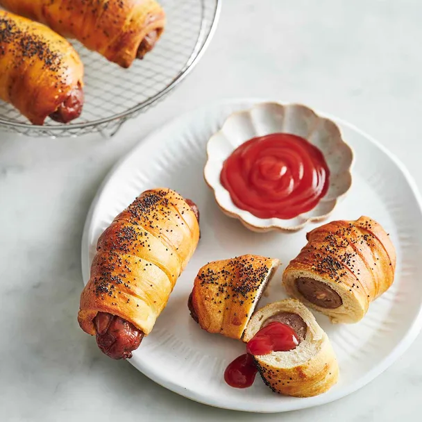 air fryer pigs in blankets on a plate with tomato sauce