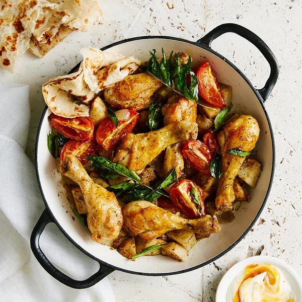 chicken drumsticks and potato in a large pot with handles