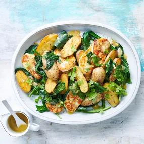 Haloumi and potato salad on a platter with a little pot of dressing on the side