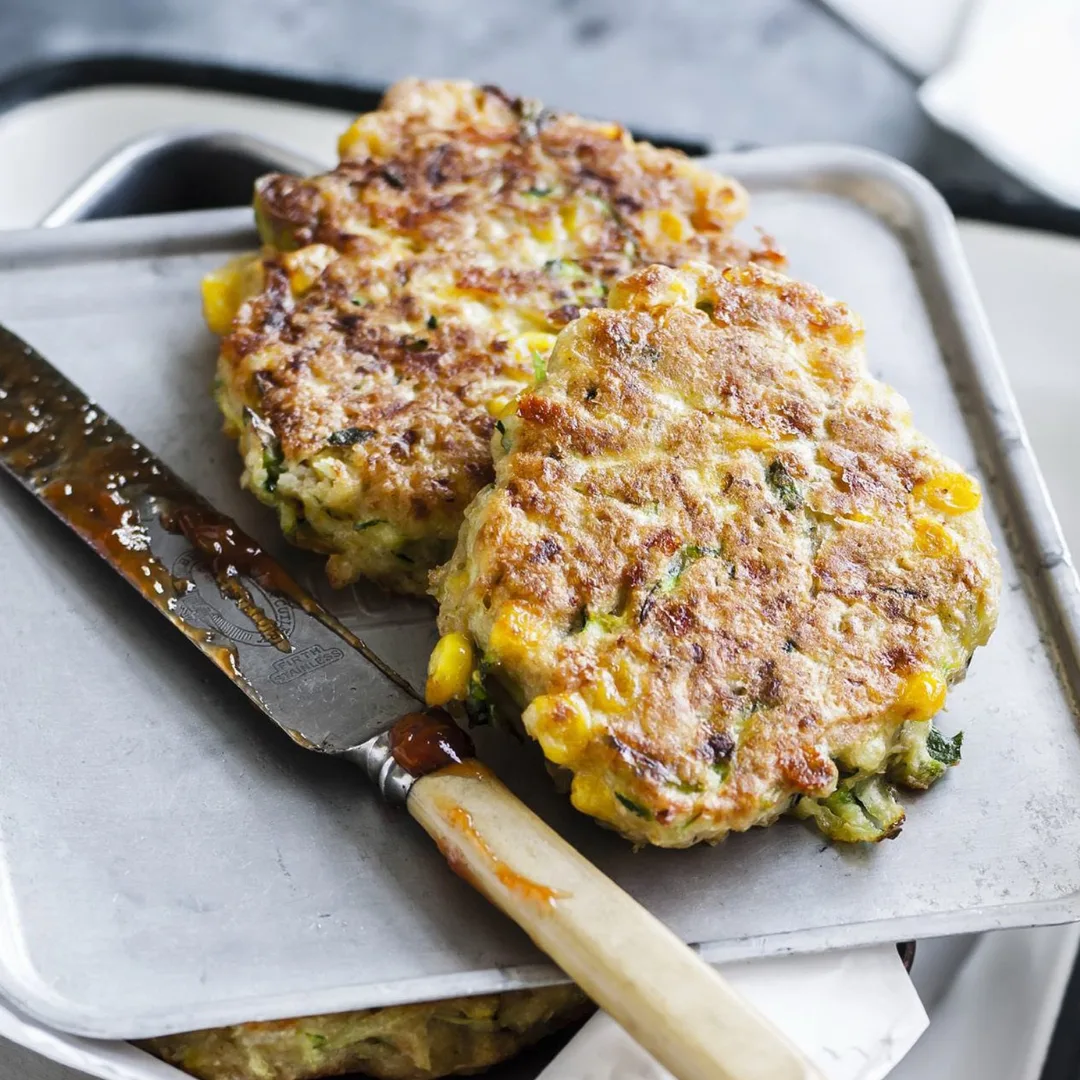 two zucchini fritters with corn and chickpeas, and a knife