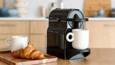 Coffee machine and croissant sitting on a modern kitchen bench