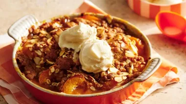 Apricot crumble in a baking dish served with vanilla ice-cream