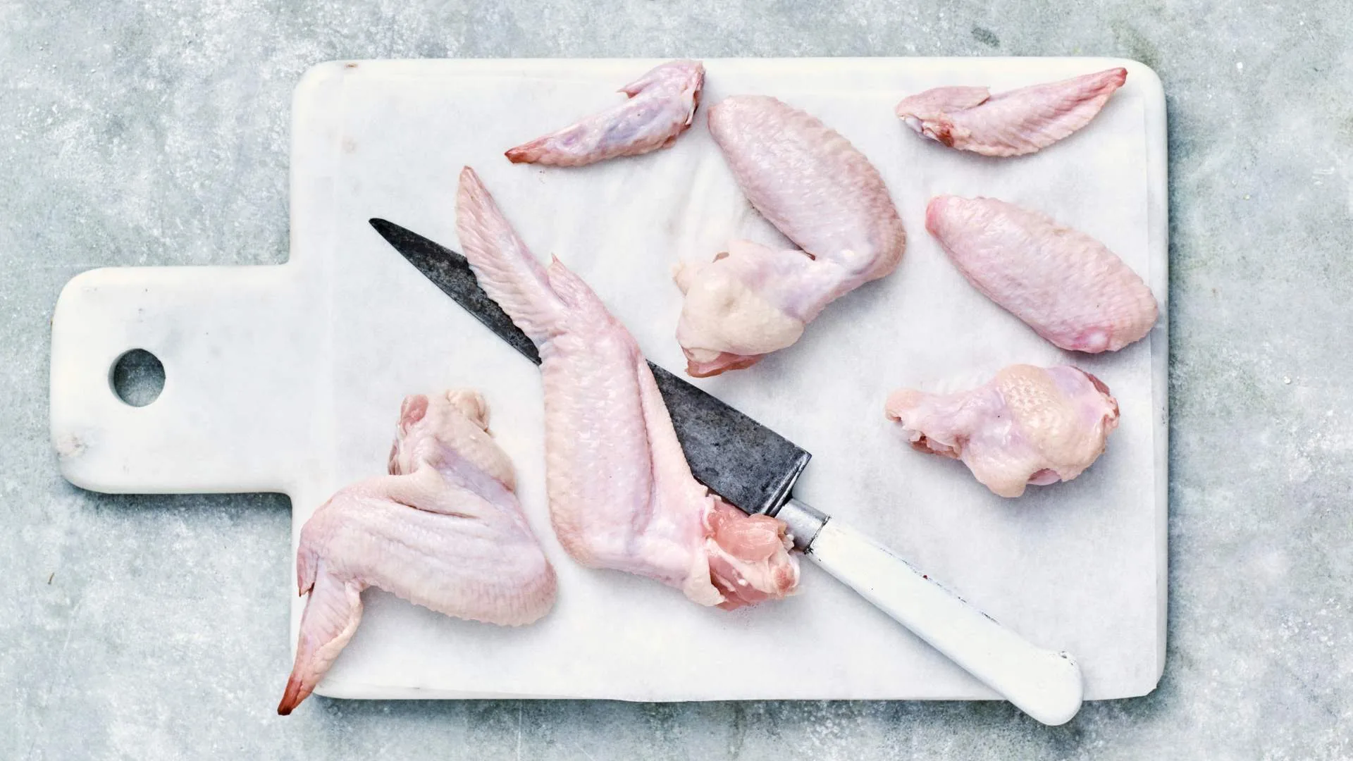 Chicken wings on a chopping board, cut into chicken nibbles 