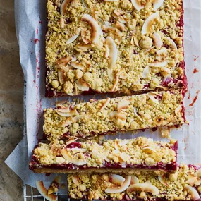 Plum crumble slice on an airing rack, partly sliced