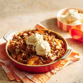 Apricot crumble in a baking dish served with vanilla ice-cream