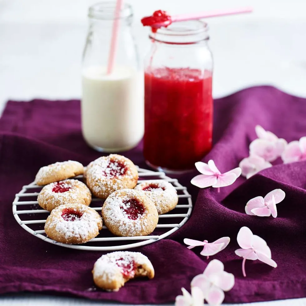 Plum jam drops on a rack, bottle of milk and jar of jam in background