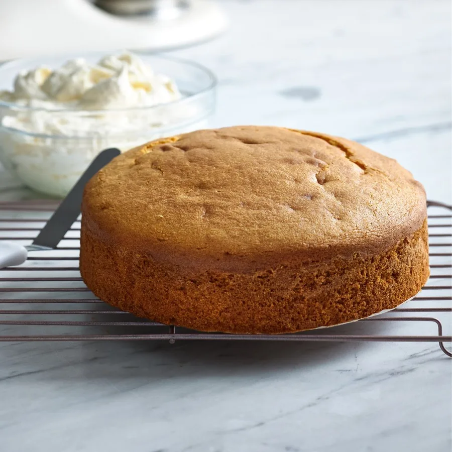 easy butter cake whole, with a bowl of icing at the back.