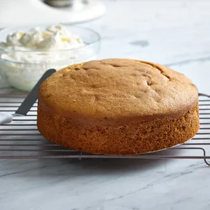 easy butter cake whole, with a bowl of icing at the back.