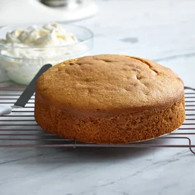 easy butter cake whole, with a bowl of icing at the back.