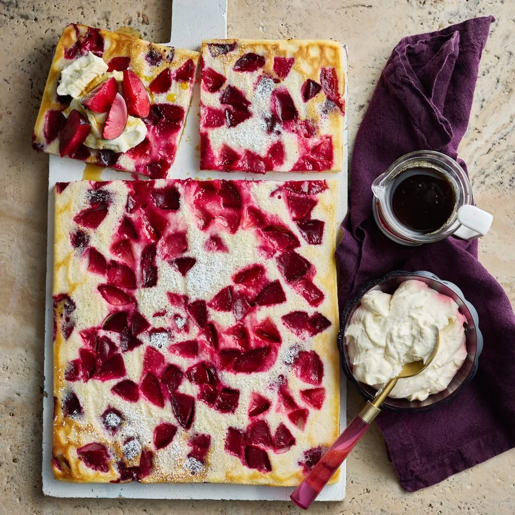 Sheet pan pancakes with plums served with whipped ricotta and maple syrup