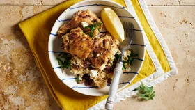 Greek lemon chicken rice recipe made with chicken thighs. In a white bowl.