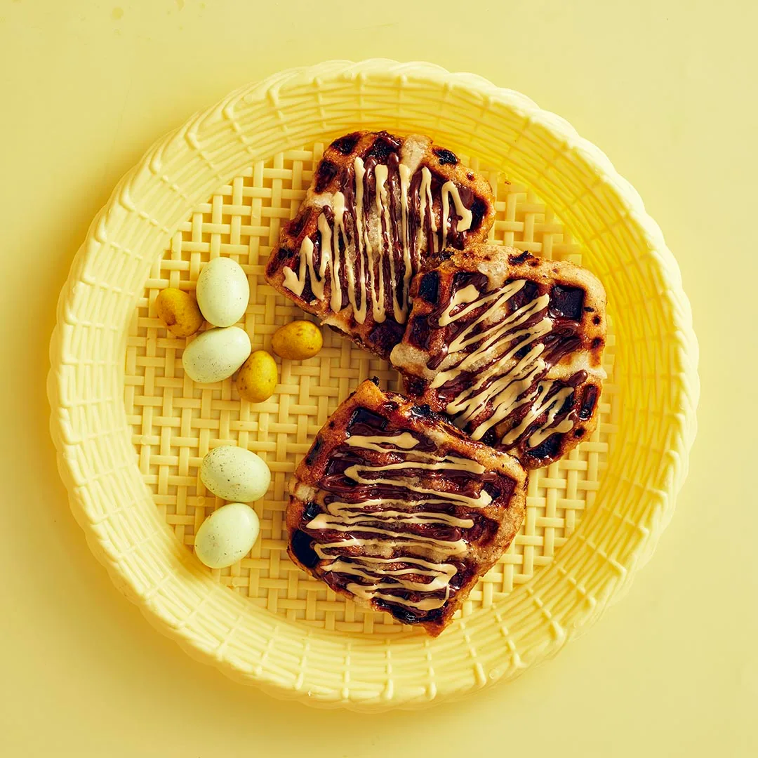 hot cross bun waffles with Easter eggs on a yellow plate