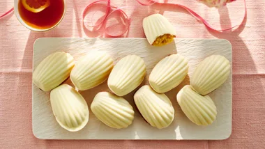 madeleines with white chocolate topping on a white platter for morning tea on mother's day